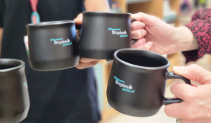 People gathering for a cup of coffee with Bruyère hospital mugs